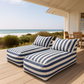 Blue and white striped outdoor lounge chairs on a wooden deck with a beach view.