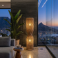 Modern living room with a large window view of a cityscape at dusk. Cape Town Twisted Cage Floor Lamp