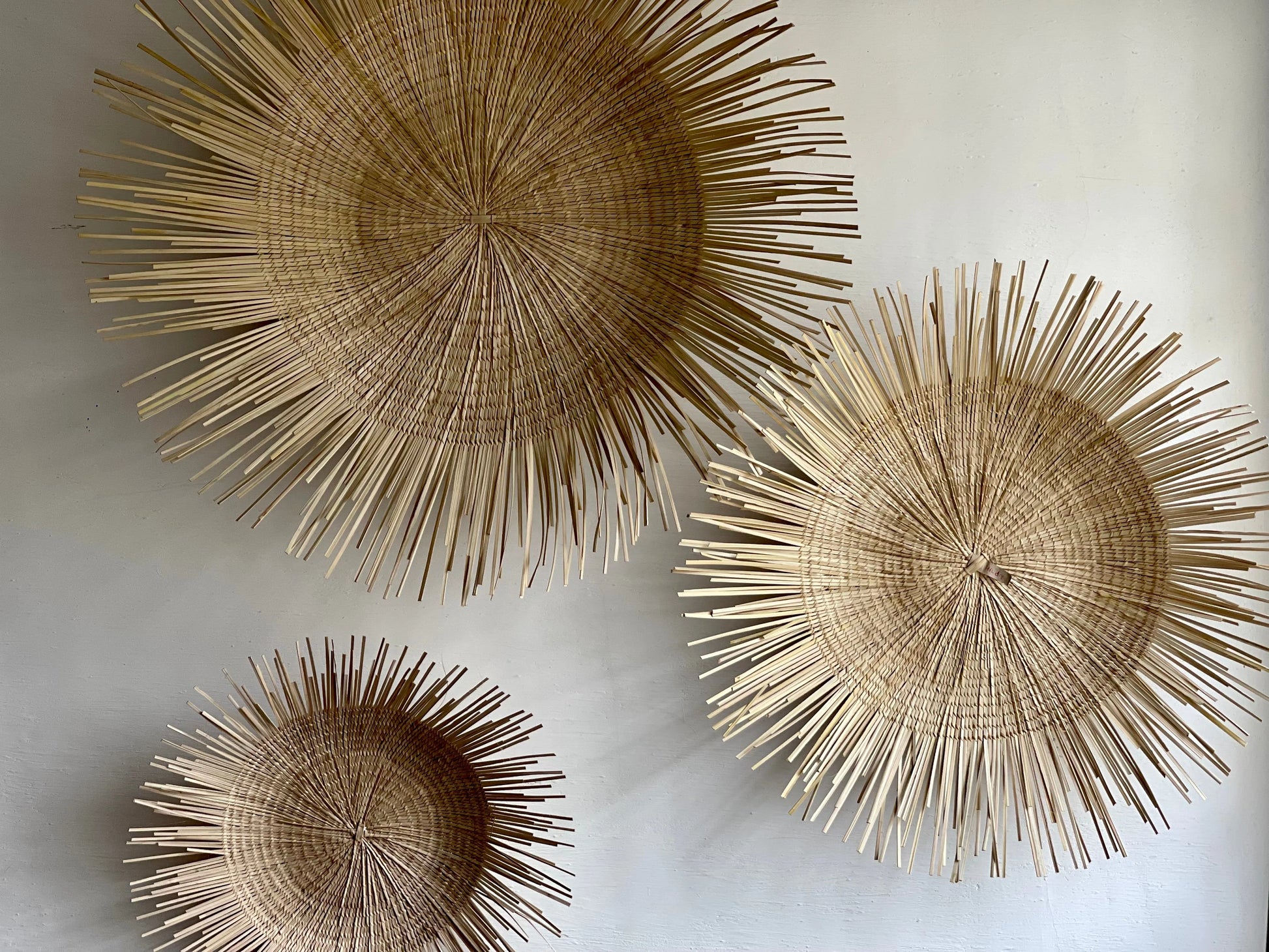 Handcrafted Sun Circle wall art. Each piece is carefully woven by Malawian craftsman, incorporating unique spikes and tendrils of ilala palm. Bring natural texture and a touch of bohemian style to your home or office!