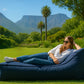 A rectangular daybed lounger with a bold blue fabric, featuring a low, boxy base and a matching angled backrest cushion. The clean white background highlights the modern, casual design and crisp piping detail along the seams.