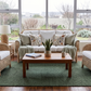Available Now - Malawi Furniture - Handwoven natural cane Malawian Couch Set with plush white cushions and a floral pillow in a cozy sunlit corner. Ideal for a relaxed lounge.