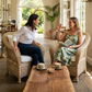 Handwoven cane Malawi chairs with white cushions are paired with a rustic, live-edge wood coffee table. This artisan-crafted set creates a natural, sophisticated focal point in a bright sunroom. Shop these unique, authentic pieces from Malawi Furniture.