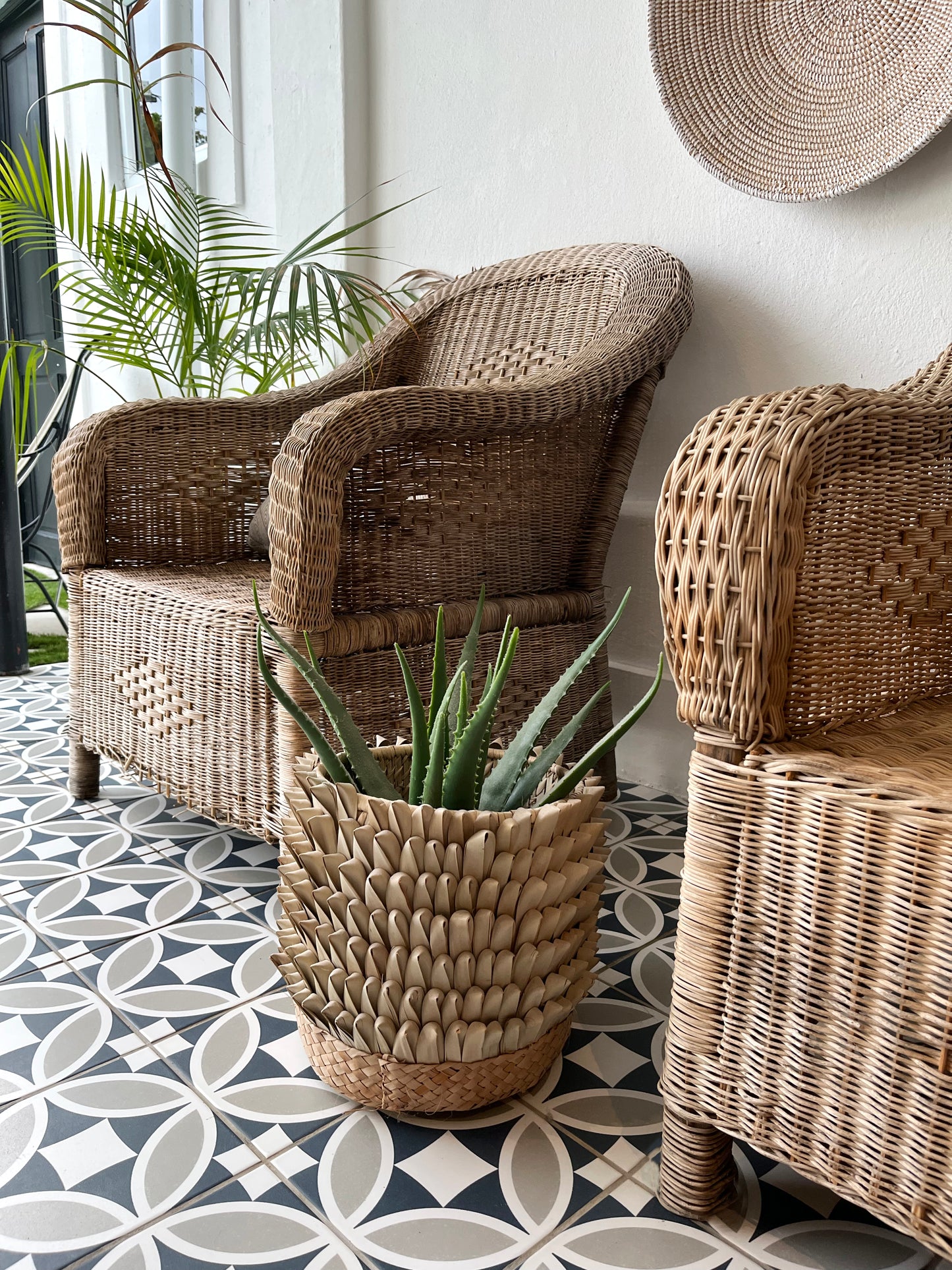 Franschhoek Guest Lodge - Handwoven cane Malawi Classic Chairs with Porcupine Planter Pot. This artisan-crafted set creates a natural, sophisticated focal point on the patio. Shop these unique, authentic pieces from Malawi Furniture.