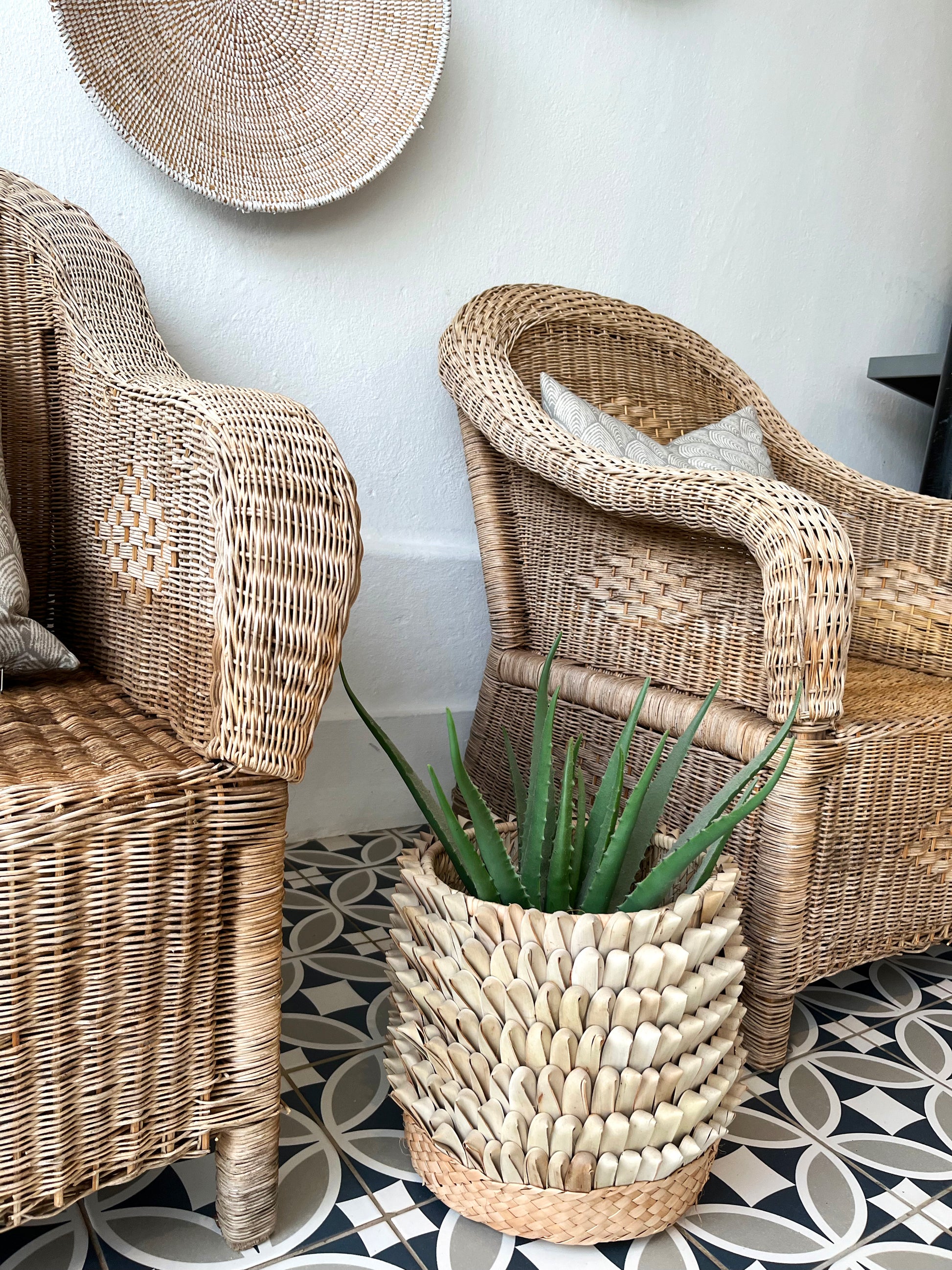 Franschhoek Guest Lodge - Handwoven cane Malawi Classic Chairs with Porcupine Planter Pot. This artisan-crafted set creates a natural, sophisticated focal point on the patio. Shop these unique, authentic pieces from Malawi Furniture.