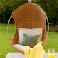Hand-woven Malawi cane Hanging POD Chair with egg-shaped, cocoon-like structure suspended by sturdy rope, shown in natural finish. The chair features an open weave and rounded form designed as a personal relaxing sanctuary, with customisable detachable cushions (natural, white, or black) for added comfort.