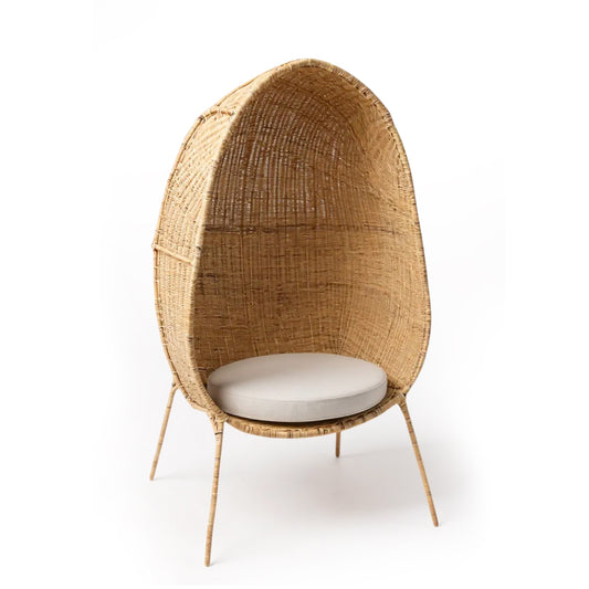 Standing EGG Chair — A handcrafted, egg-shaped chair woven from natural Malawian cane, featuring an elegant cocoon silhouette that rests on a sleek, four-legged metal stand. The chair includes a removable plush cushion (available in natural, white, or black) that enhances comfort and style. This artisanal piece combines organic textures with modern minimalism, making it a striking focal point for both indoor and outdoor spaces.