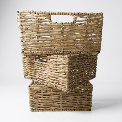 Stack of three woven baskets on a white background