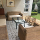 Outdoor patio with wicker furniture and a glass coffee table on a patterned rug.